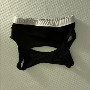 Black sports bra with a white band and an open back